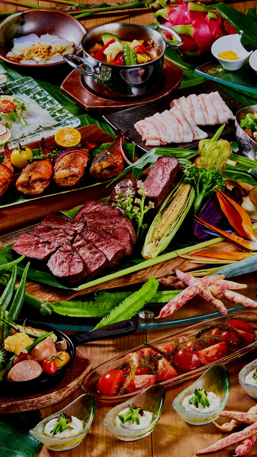 色とりどりの沖縄食材をふんだんに使った贅沢なビュッフェ料理の数々。中央の厚切りローストビーフをはじめ、ゴーヤや海ぶどう、沖縄そば、アグー豚のしゃぶしゃぶ、島野菜のグリルや南国フルーツなどがテーブルいっぱいに並んでいます。